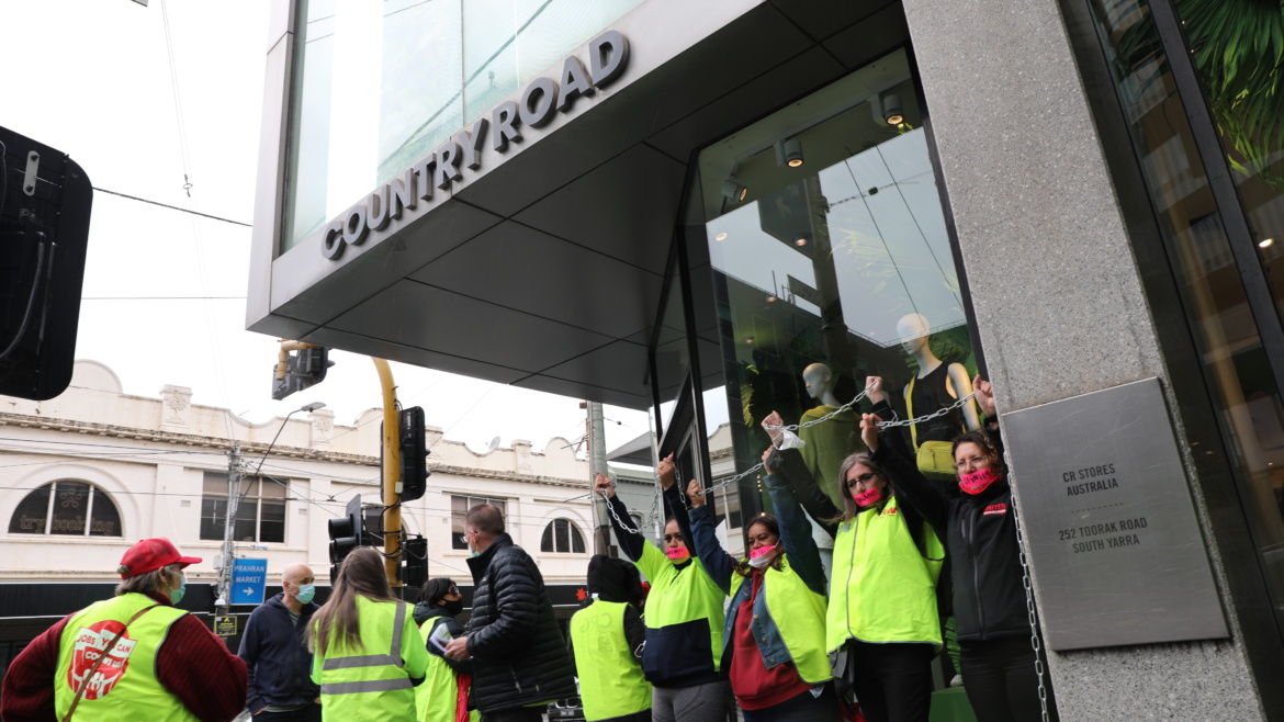 Workers in hi vis chained together outside of a Country Road store in Melbourne