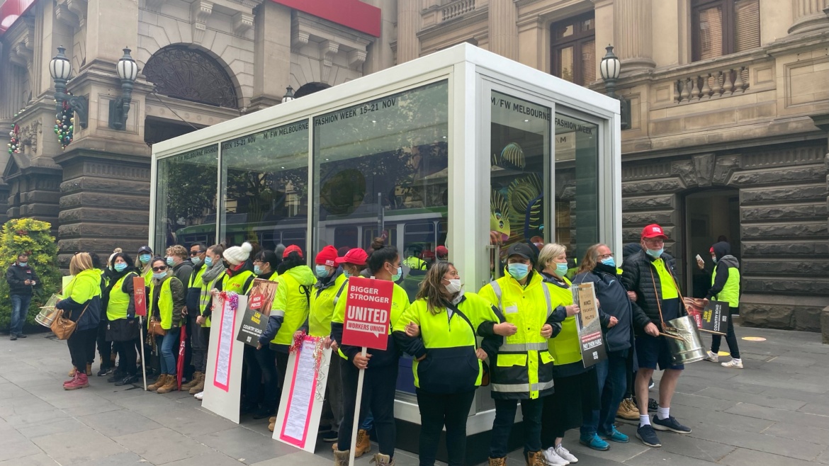 Workers in hi vis chained together outside of a Country Road store in Melbourne
